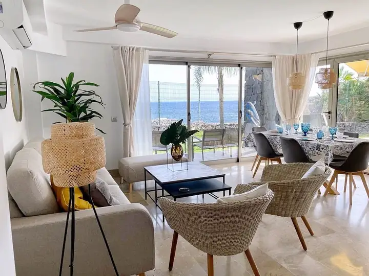 Bright living room with sofa, armchairs and sea view